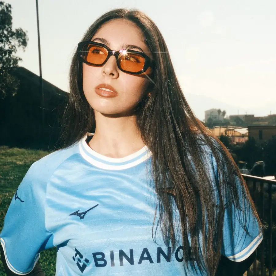 Frau mit Sonnenbrille im hellblauen Trikot